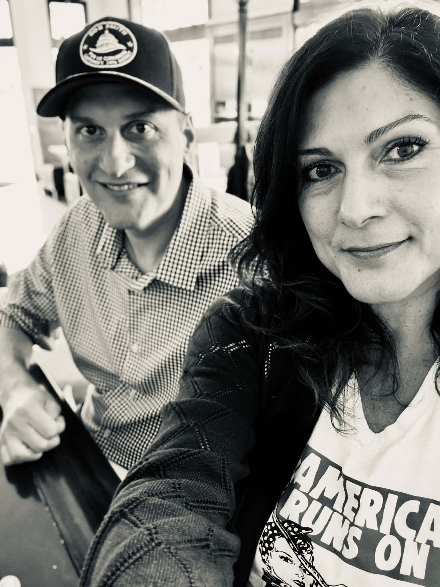 Bob Smith and his wife Adriana, photographed together in black and white. He is wearing a Bob Smith campaign cap and a checked shirt.