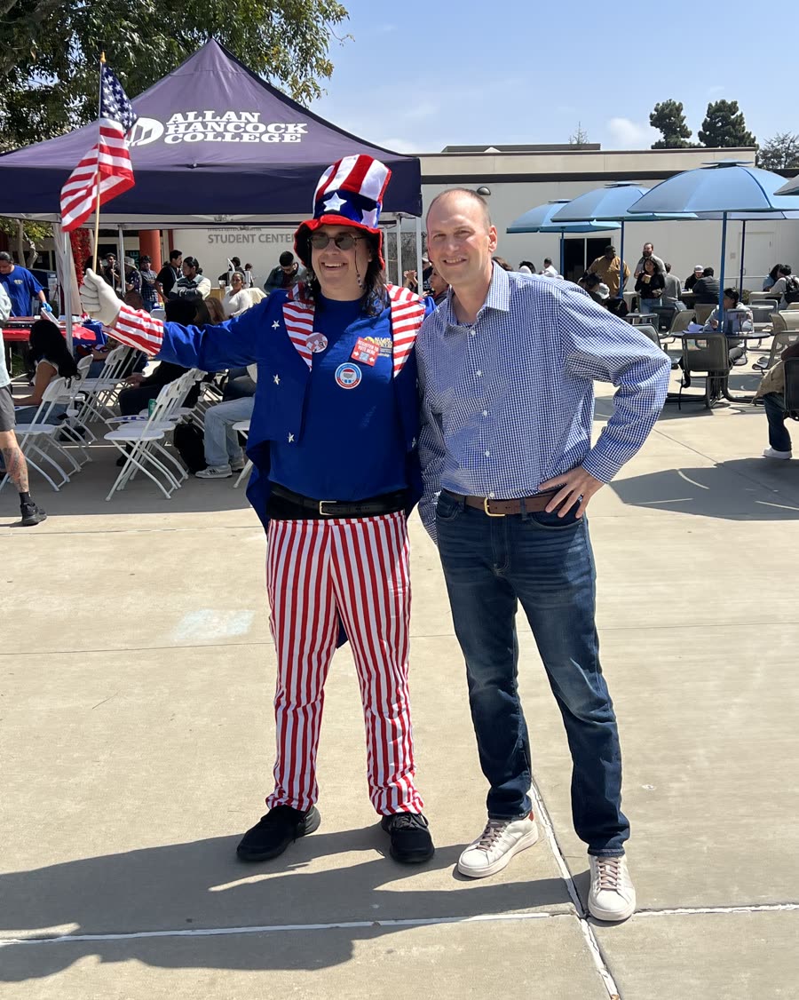 Bob Smith at a community day on a college campus beside a volunteer in an Uncle Sam costume