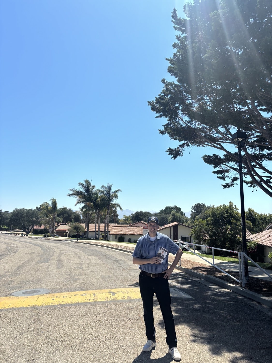 Bob Smith on a residential street in Vandenberg Village holding campaign literature