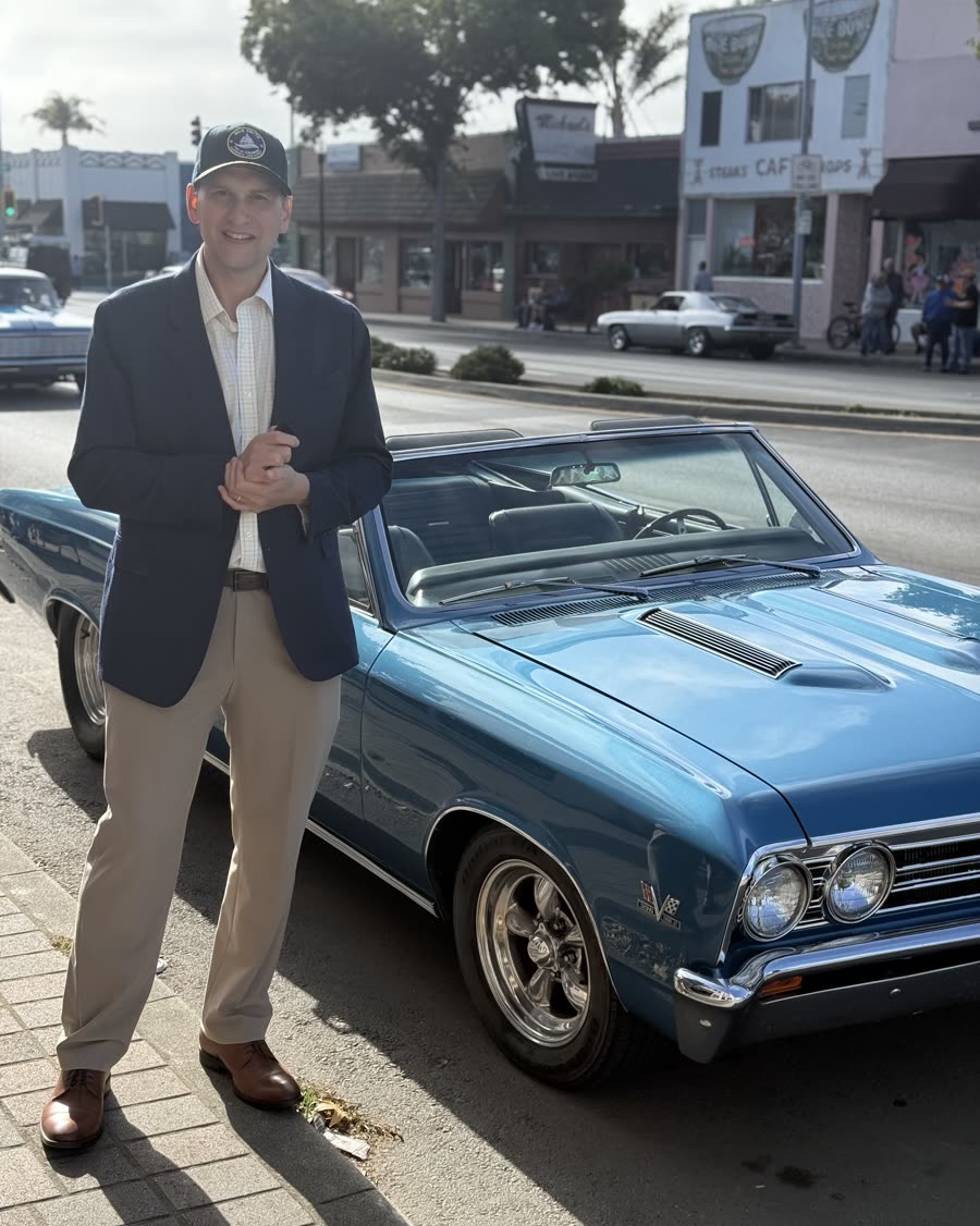 Bob Smith beside a classic convertible at a main street car show